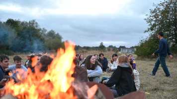 People sitting and chatting around a firepit.