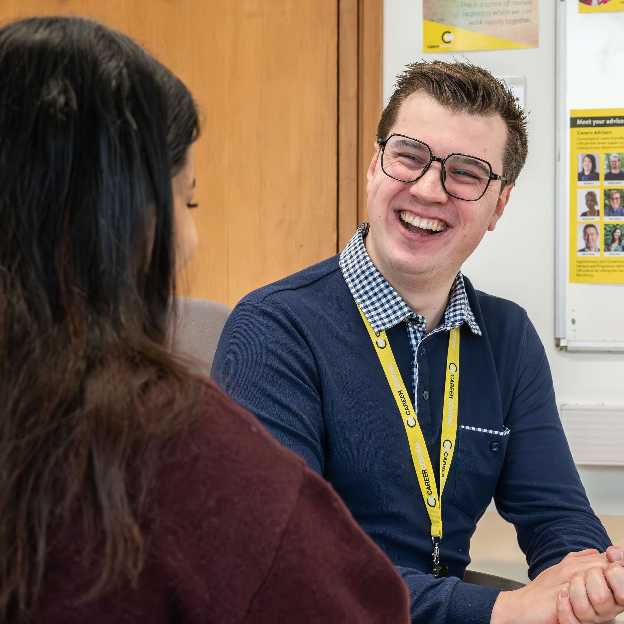 Career adviser smiling and listening to a student during an employability support session.