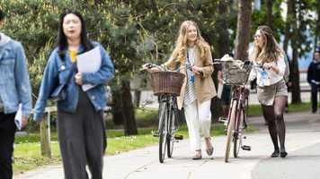 Students pushing their bikes together on campus