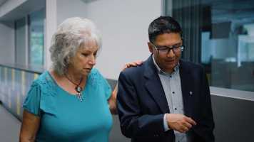 A researcher and a fundraiser walk down a hall discussing a new imaging technology.