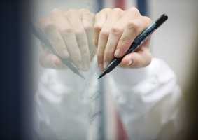 pharmacy student writing on board with black pen