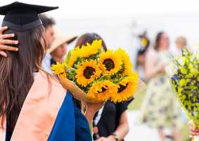 graduate holding flowers