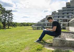 Student sitting outside ziggurat in the sunshine
