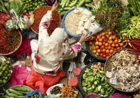 asian woman at vegetable and spices market