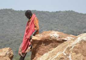 Indigenous woman leaning on a rock in the mountains
